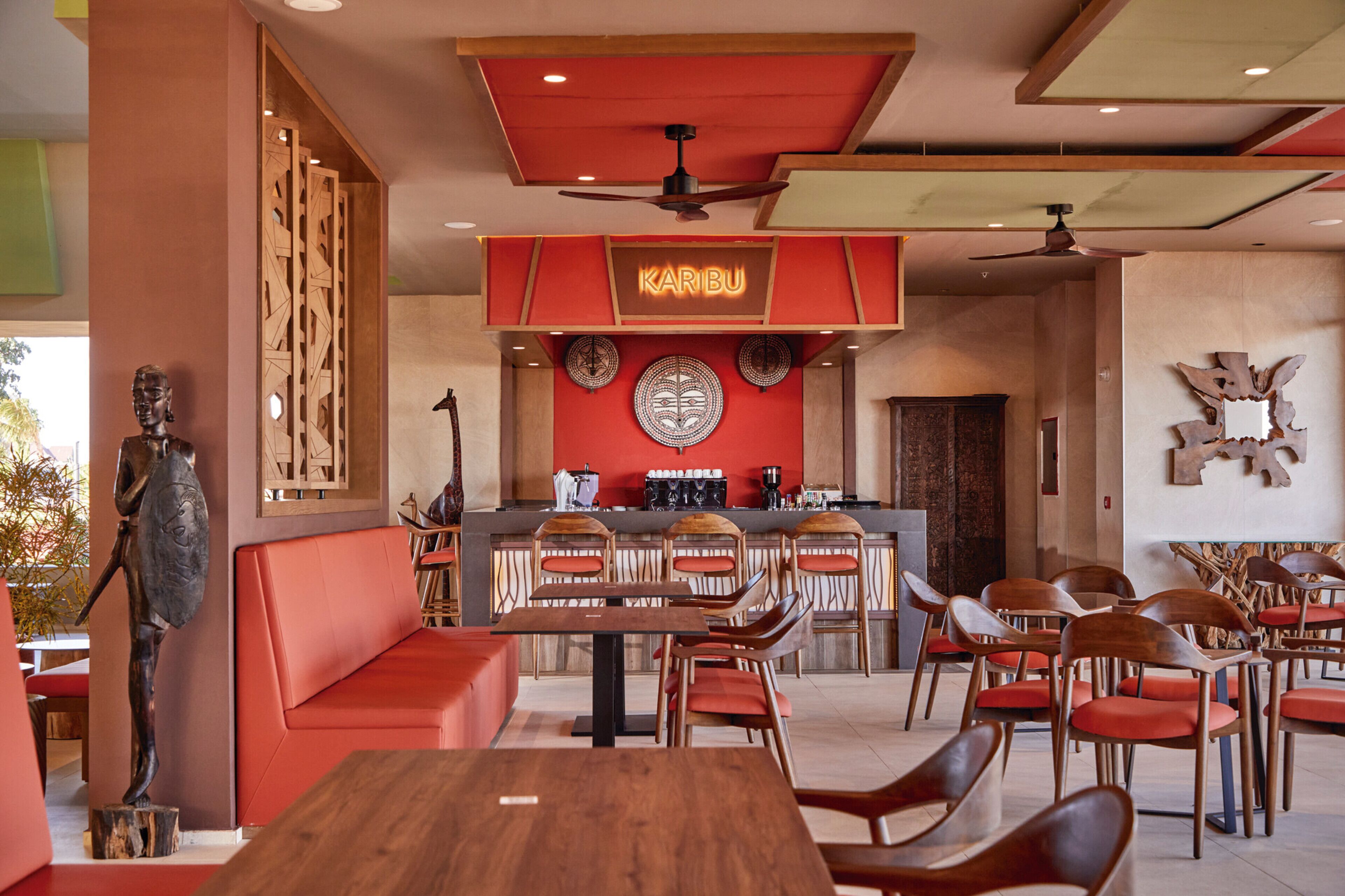 A restaurant interior with a red and beige color scheme, wooden furniture, and a central bar area.