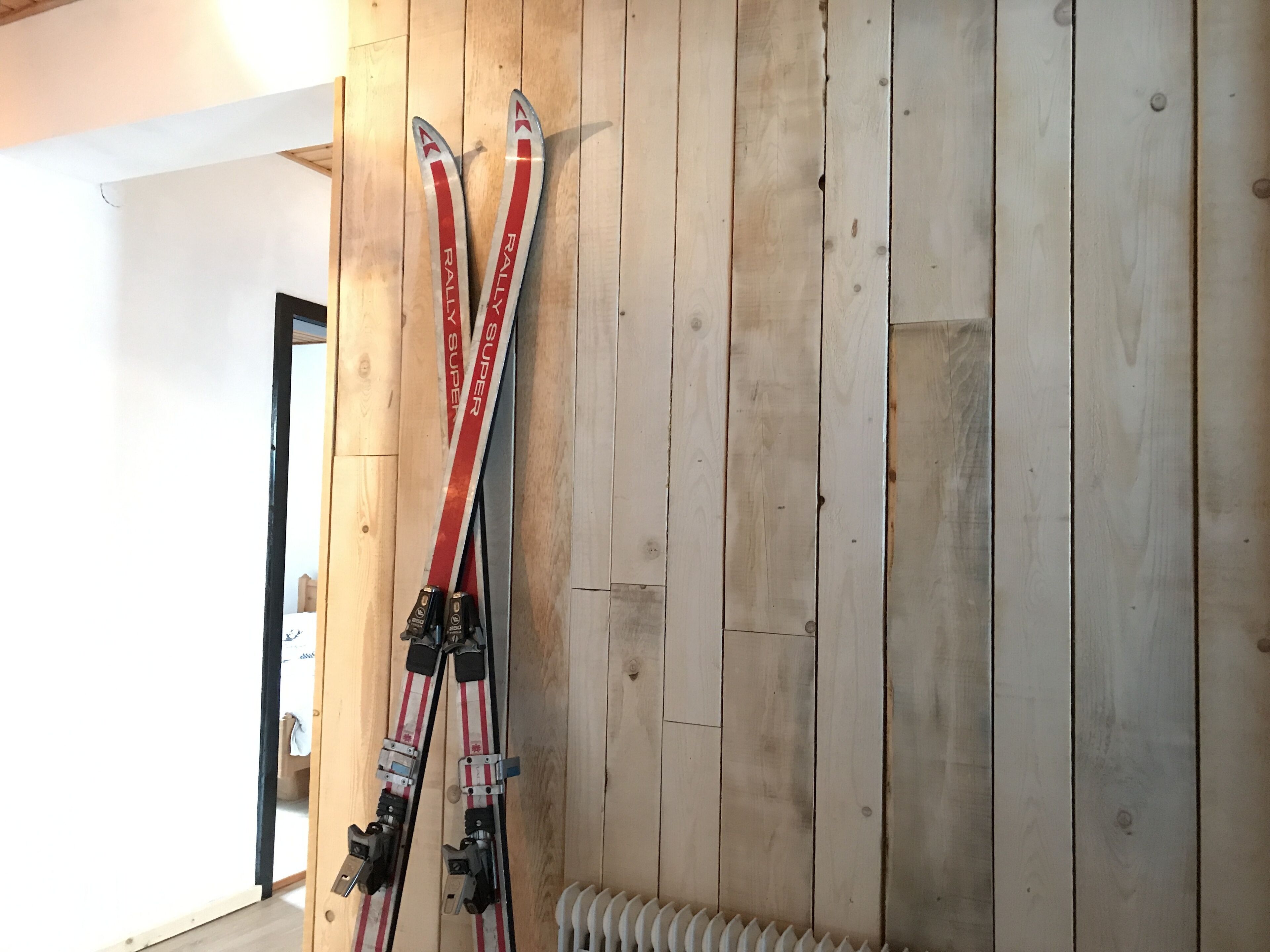 A wooden wall with skis leaning against it.
