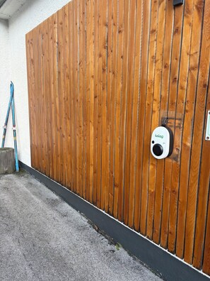 A wooden fence with a security camera mounted on it.