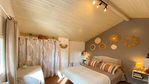 Un dormitorio con una cama grande, una mesita de noche y una repisa en la pared.