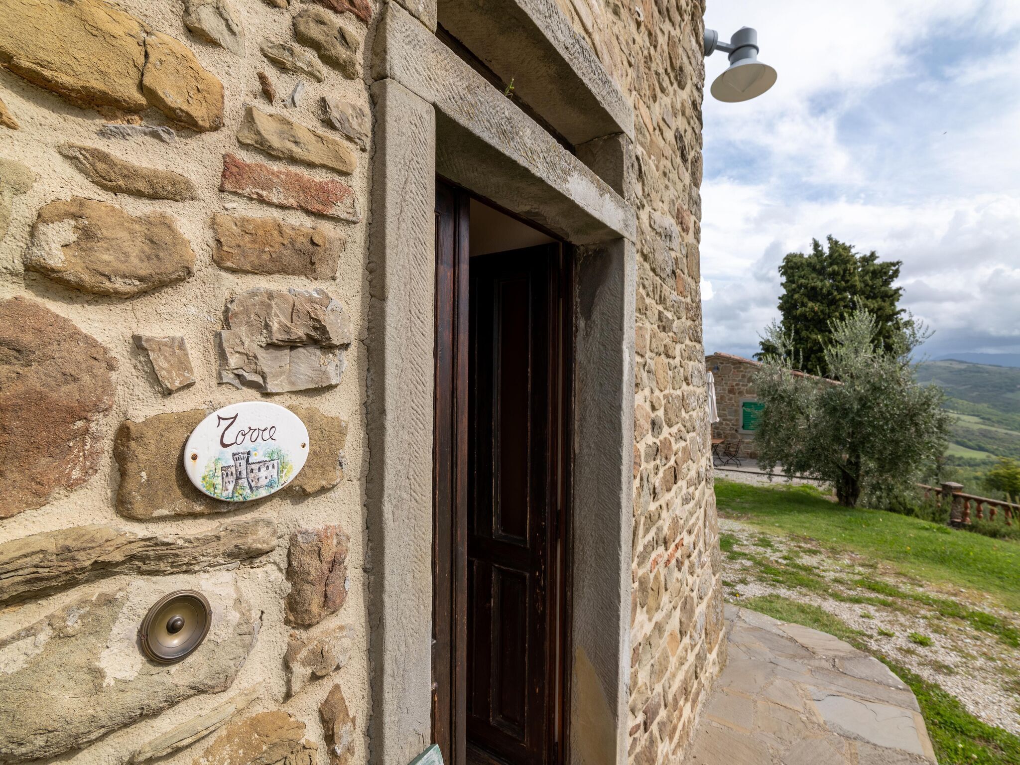 Un edificio de piedra con una puerta de madera y un letrero que dice "Zoroc".
