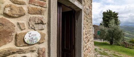 Un edificio de piedra con una puerta de madera y un letrero que dice "Zoroc".