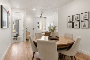 A dining area with a round wooden table, six chairs, and a potted plant. - Red Rock Oasis #93 by RedAwning (St. George)