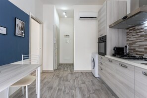 A compact kitchen with a dining area, a washing machine, and a sign that says 'LOVE'.