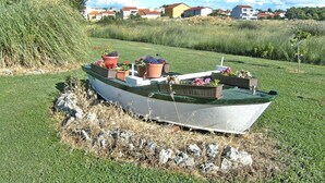 Een boot met potplanten op een grasveld.