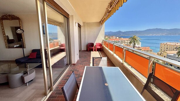 A balcony with a table and chairs, a sofa, and a mirror. - Ajaccio: Air-conditioned 4-room apartment, 6 beds, downtown (Ajaccio)