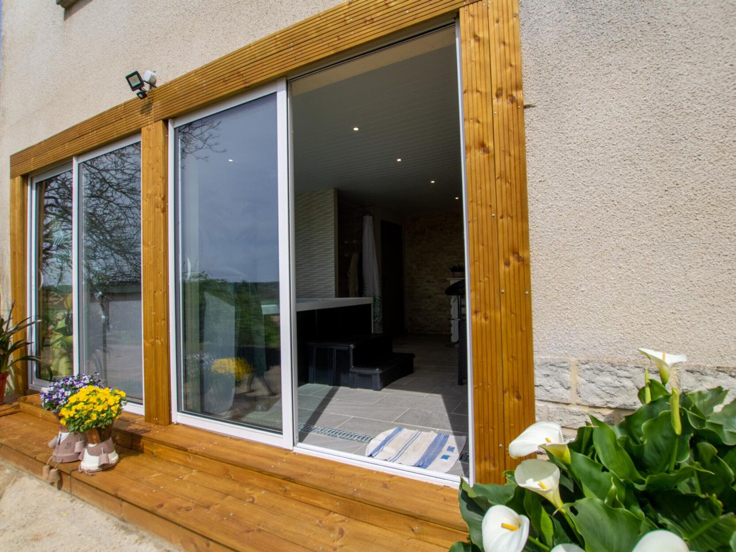 A modern house with large sliding glass doors leading to a spacious interior.
