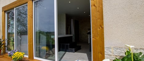 A modern house with large sliding glass doors leading to a spacious interior.