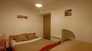 Una camera da letto con un letto singolo, un comodino, un tavolo e un poster appeso al muro.