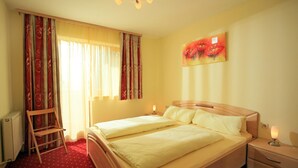 Une chambre d’hôtel avec un lit double, une table de chevet avec une lampe, une chaise et un radiateur.