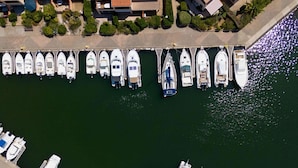 An aerial view of a marina with numerous boats docked in a row.
