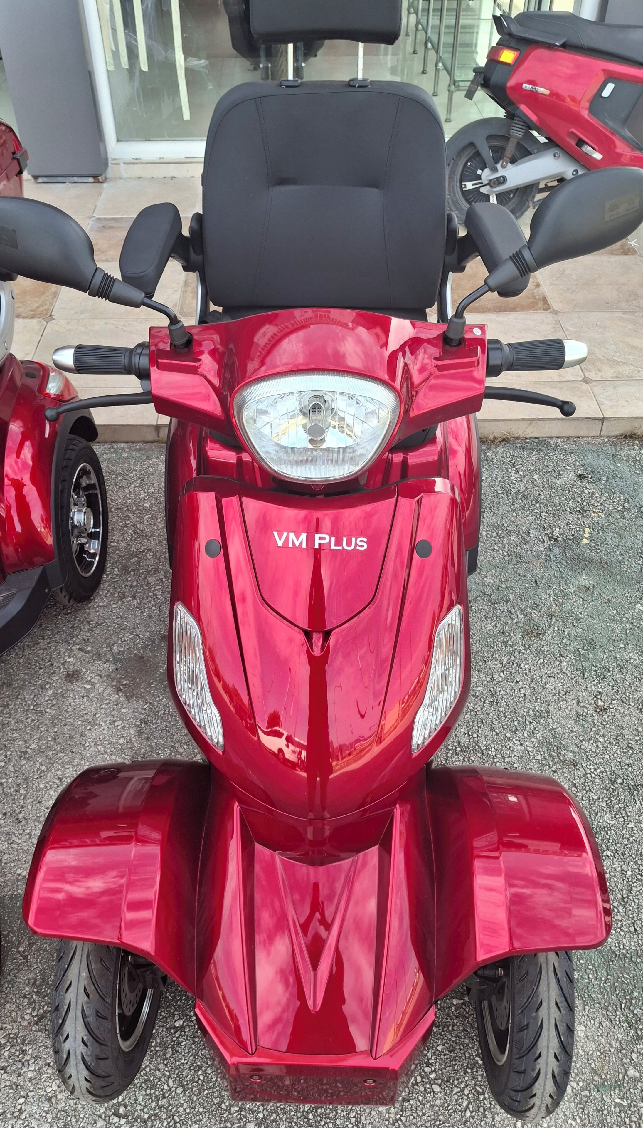 A red scooter with the label 'VM PLUS' on the front.
