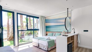 A modern hotel room with a bed, a small kitchenette, a large window with a view of palm trees, and a beach mural on the wall. - Alannia Salou Resort  (Salou)