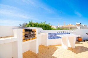 Enjoy al fresco dining and relaxation on this outdoor patio, featuring a barbecue grill and comfortable seating area.