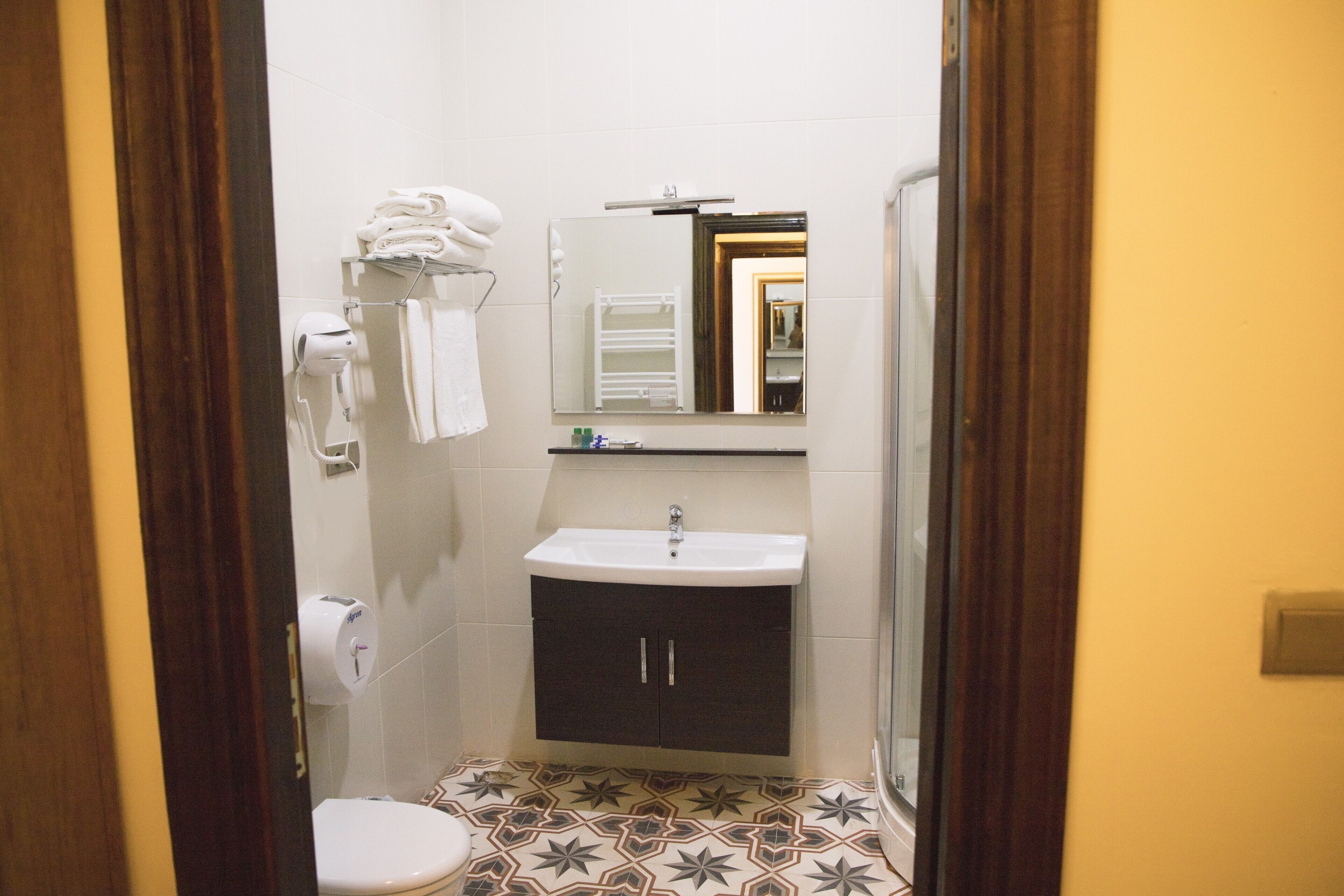 Un baño pequeño con inodoro, lavamanos y perchero para toallas.