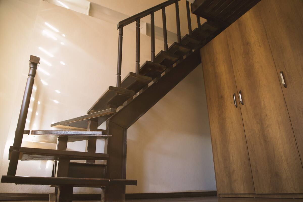 Una escala de fusta amb barana que condueix a una plataforma.