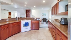 A spacious kitchen with a central island, a built-in oven, and a dining area with a table and chairs. - Pismo Vacation Multi-Family Home (San Diego)