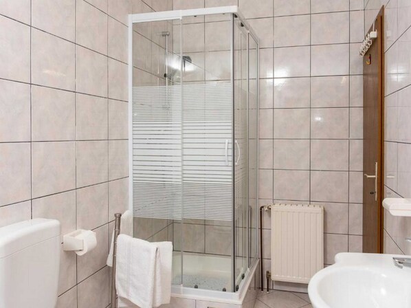 A modern bathroom with a glass-enclosed shower, a white toilet, and a sink. - Holiday Home Mons Aureus (Split)