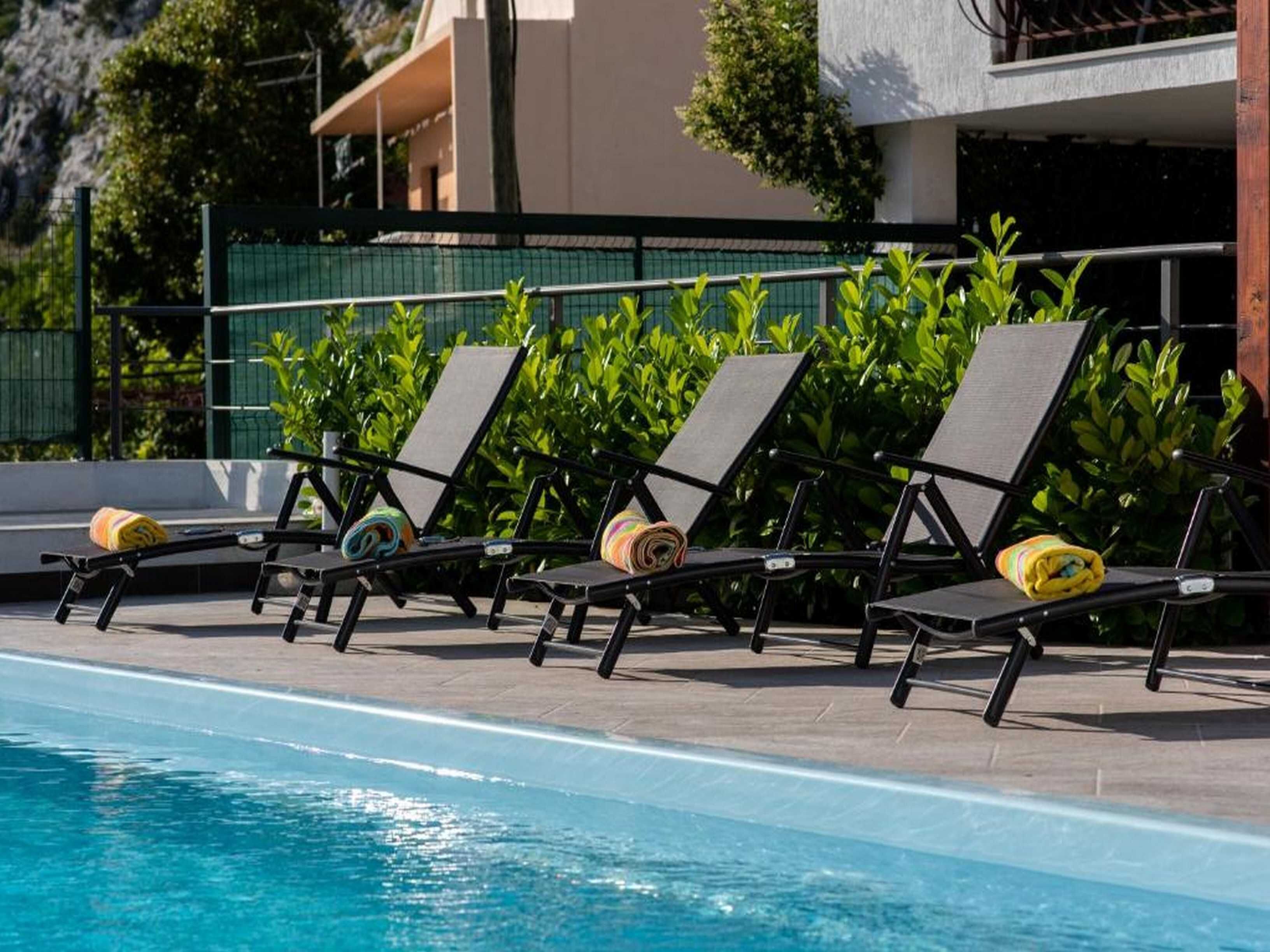 A poolside area with lounge chairs and a pool.