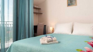 A hotel room with a bed, a painting on the wall, and a window with curtains. - Holiday Home Mons Aureus (Split)