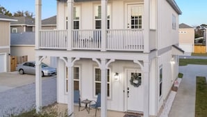Une maison à deux étages avec un balcon, un porche à l’avant et un garage.