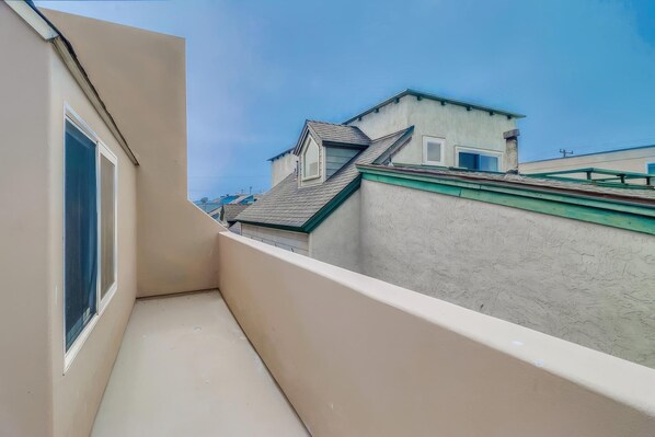 Un balcón con vistas a edificios cercanos y un cielo despejado.