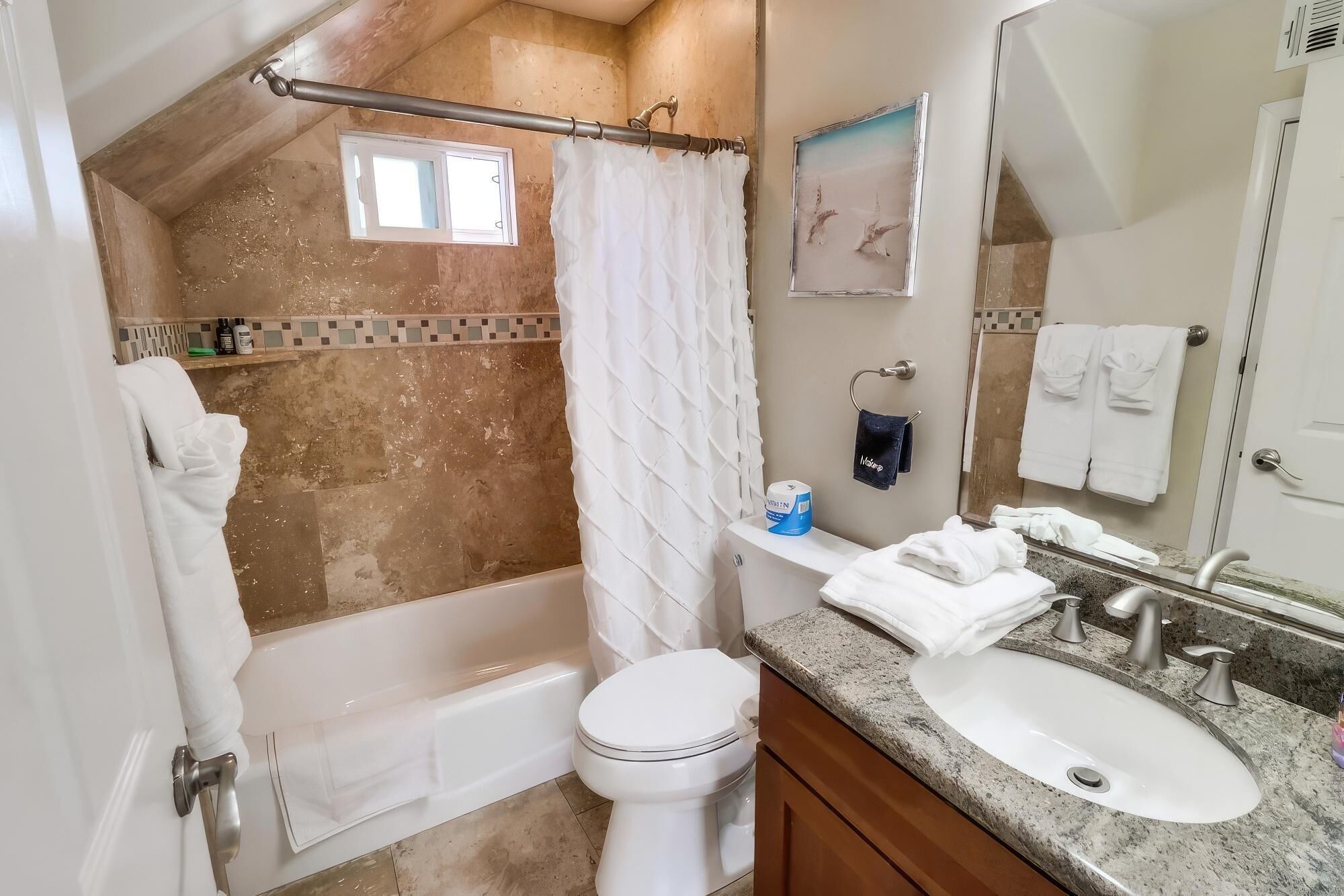 A bathroom with a bathtub, toilet, and sink.