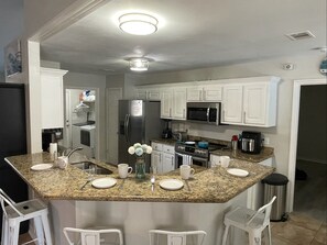 Enjoy cooking in this well-equipped kitchen with a central island, gas stove, and refrigerator.