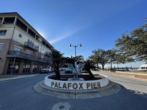 Een straatnaambord voor Palafox Pier, met een decoratief engelbeeld.