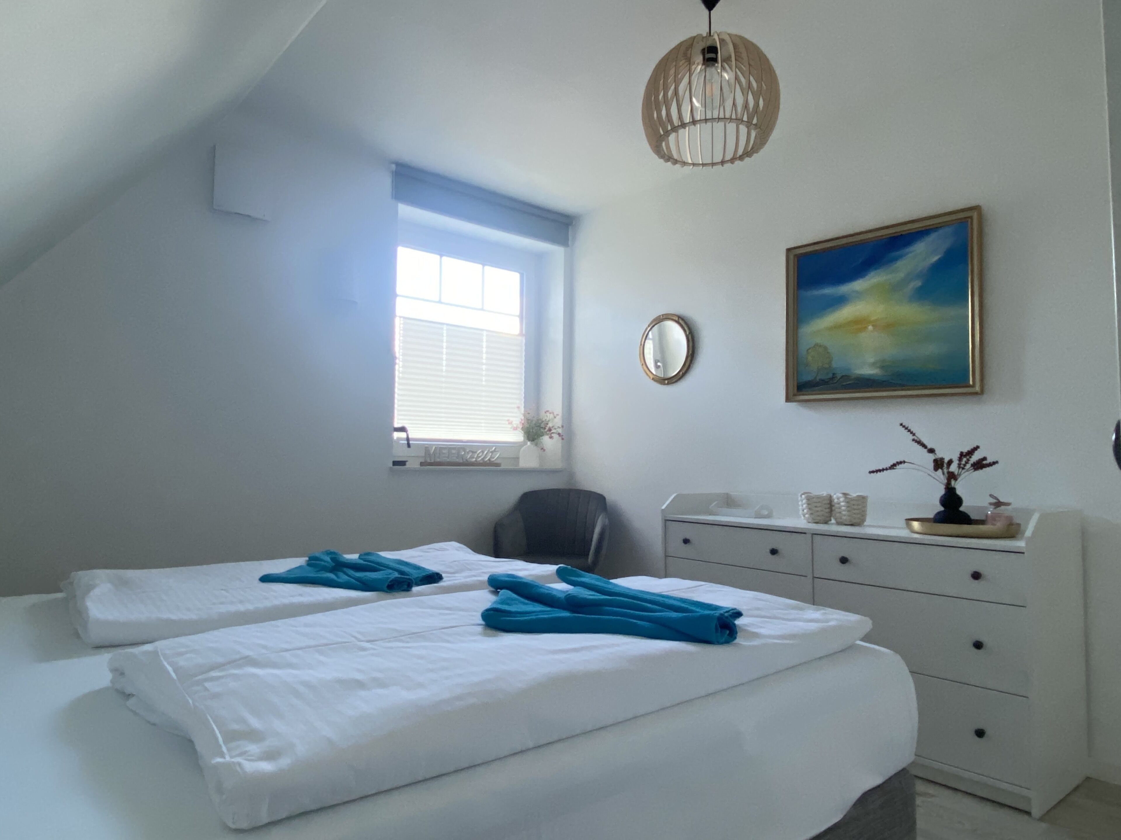 Un dormitorio con dos camas, un aparador, un espejo, una ventana y un cuadro.