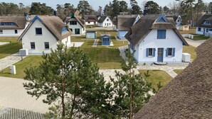 A cluster of traditional-style houses with thatched roofs, arranged in a small village setting. - Vacation home under thatch on Usedom for 6 people with sauna and wood-burning stove, wall box. (Zirchow)