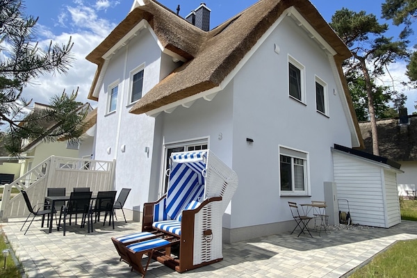 Skandinavisch eingerichtetes Reetdachhaus mit Strandkorb und Außen-Sitzbereichen