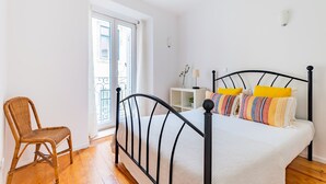 A bedroom with a bed, a chair, and a window. - 2BR at Chiado Historical Heart of Lisbon (Lisbon)