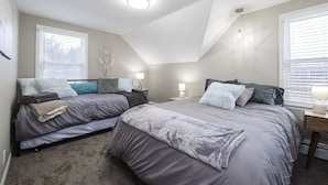 A bedroom with two beds, a skylight, and a dreamcatcher on the wall. - 1 Block to Allianz Field • Sleeps 8+ • Patio & Parking (Saint Paul)
