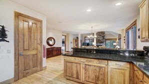 Una cocina amplia con armarios de madera, una encimera de granito y un protector contra salpicaduras de piedra.