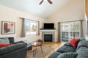 Relax in this stylish living room with a fireplace, flat-screen TV, and comfortable sofas.