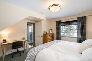 Comfortable accommodations feature a large bed, desk, and dresser.