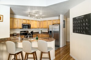 A modern kitchen with wooden cabinets, stainless steel appliances, and a granite countertop. - Quail Run 5 3 Bedroom Condo by RedAwning (Steamboat Springs)