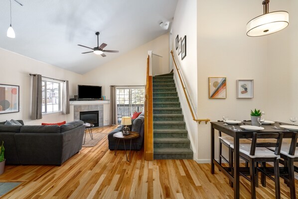 Relax in this spacious living area with a large flat-screen TV, comfortable sofa, and dining table.
