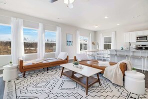 A modern living room with a sectional sofa, a coffee table, and a patterned rug.