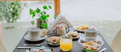 A breakfast table with a cup, bowl, and book.