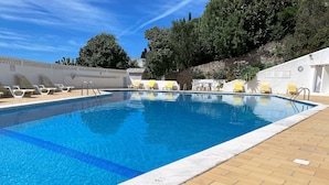 Une piscine rectangulaire à l’eau d’un bleu limpide, entourée d’une terrasse carrelée.