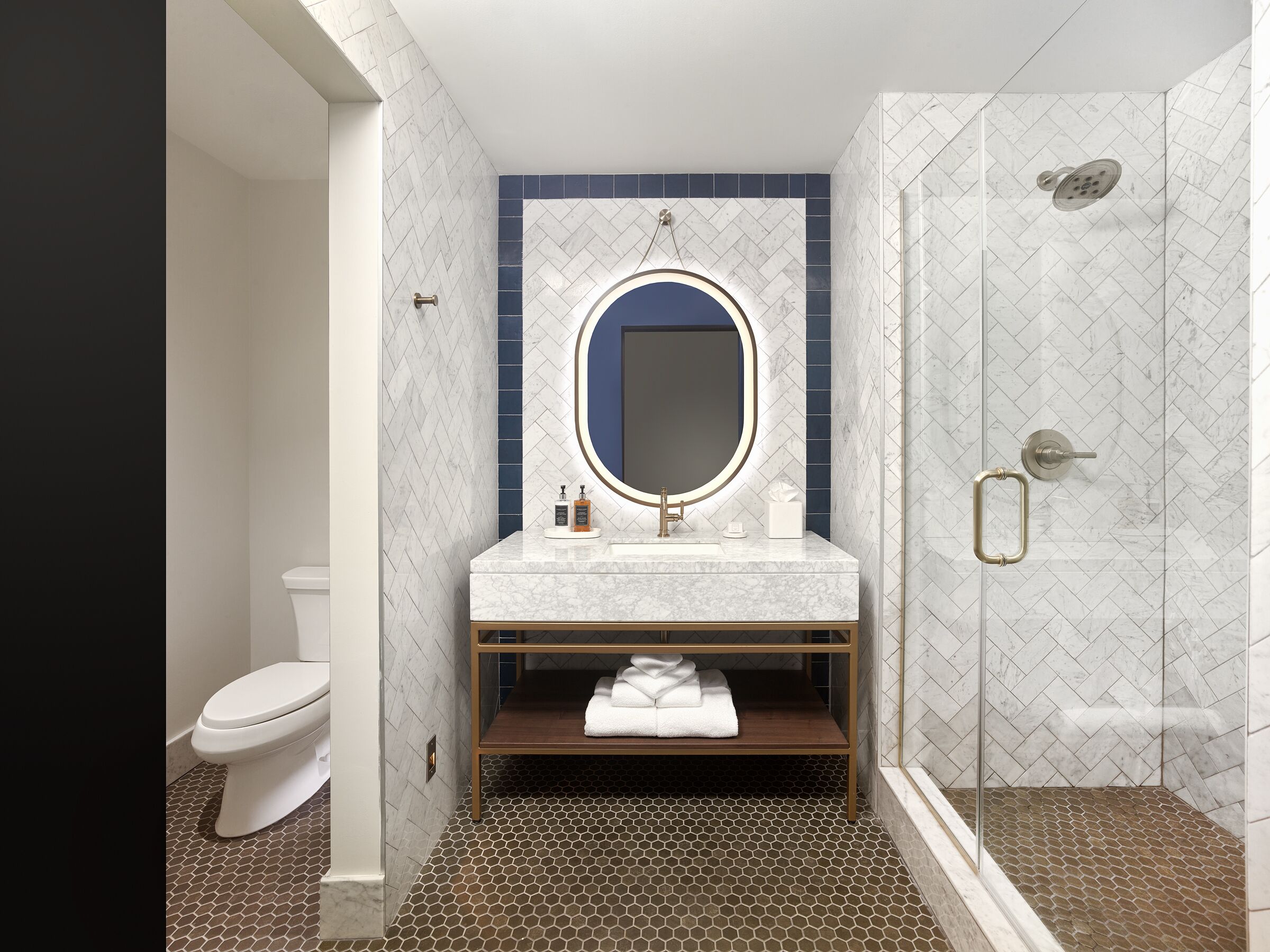 A modern bathroom with a white toilet, a vanity with a mirror, and a shower area.