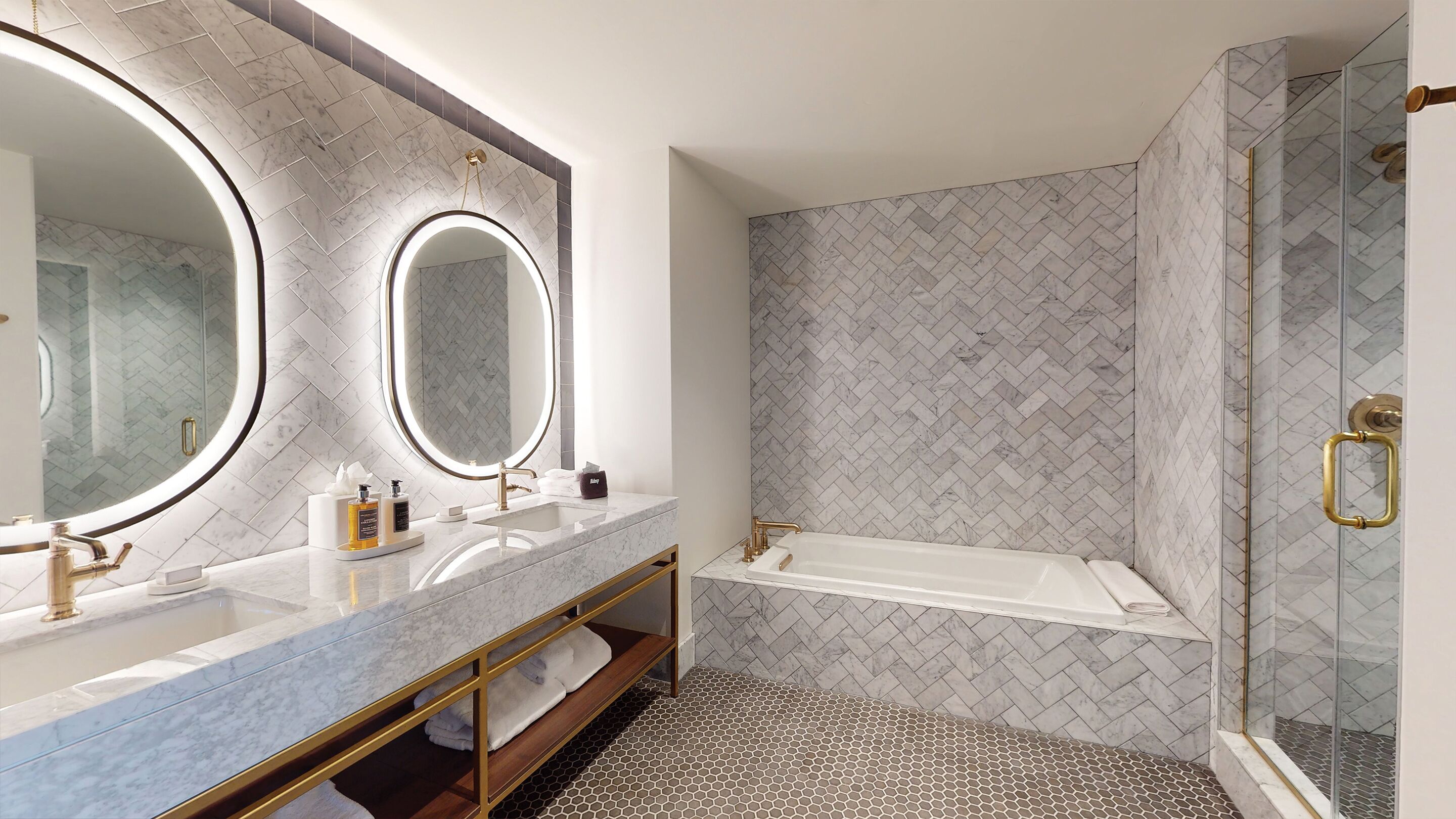 A modern bathroom with two sinks, a large mirror, and a shower area.