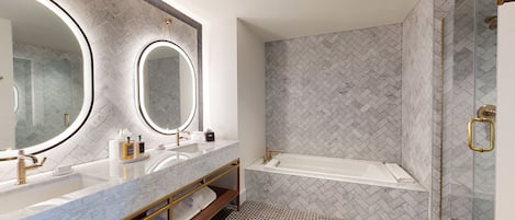 A modern bathroom with two sinks, a large mirror, and a shower area.