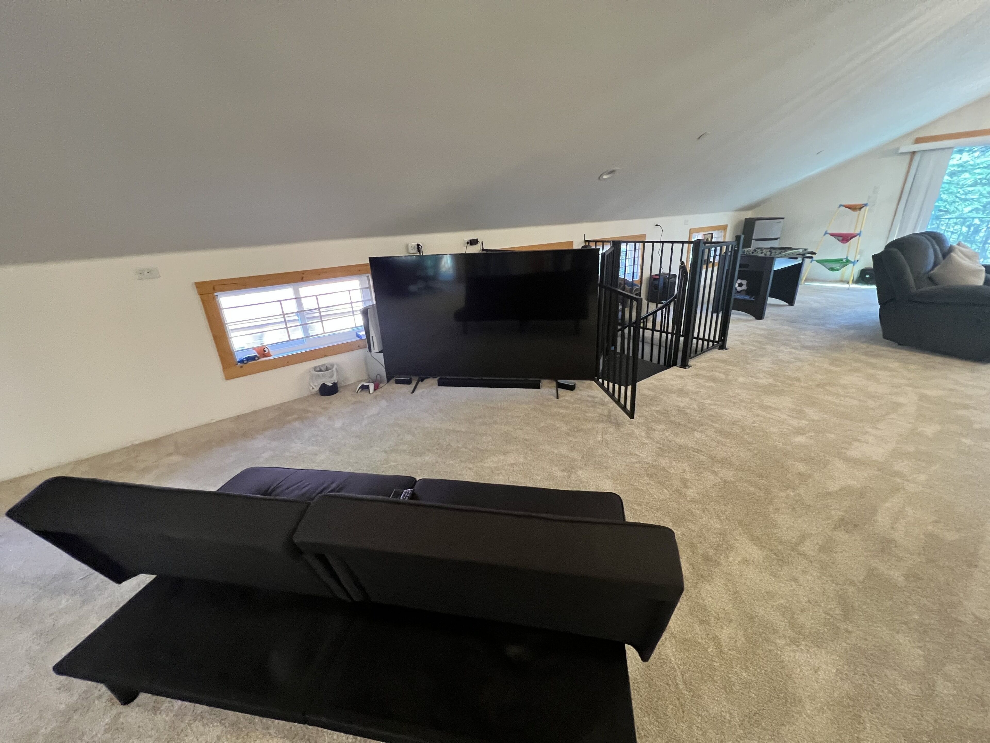 A modern living room with a large flat-screen TV, a sofa, and a coffee table.