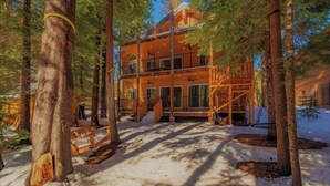 A multi-story lodge with a wooden exterior, surrounded by tall pine trees and snow on the ground. - 5 bed 5 bath cabin 5 min to the Slopes or Mountain Biking (Truckee)