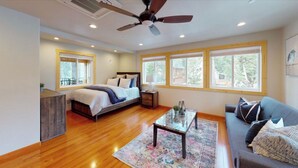 A spacious bedroom with a large bed, a nightstand, a dresser, a coffee table, and a sofa. - 5 bed 5 bath cabin 5 min to the Slopes or Mountain Biking (Truckee)