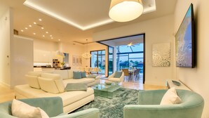 Ein modernes Wohnzimmer mit einer Sofagarnitur, einem Couchtisch und Blick ins Freie.