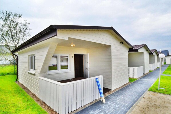 A row of white mobile homes with a porch and a number '3' sign.